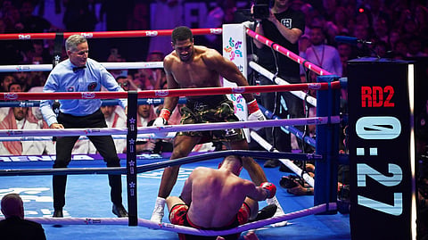 Britain's Anthony Joshua knocks down Albania's Kristian Prenga during their heavyweight title fight in Jeddah, Saudi Arabia, Sunday, July 26, 2026.