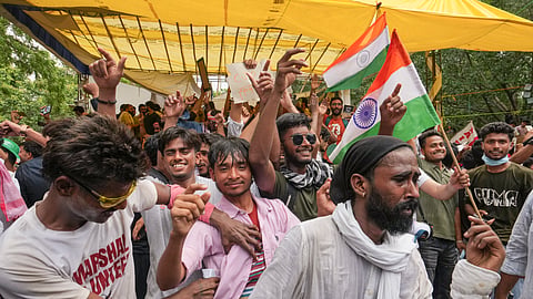 Cockroach Janta Party (CJP) supporters celebrate after Union Education Minister Dharmendra Pradhan resigned and took responsibility for the NEET paper leak, at Jantar Mantar in New Delhi, Saturday, July 25, 2026.