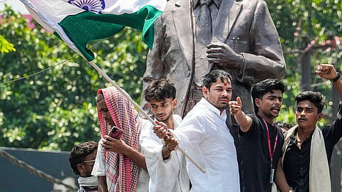JJD leader Tej Pratap Yadav stands atop the statue of former Mauritius Prime Minister Seewoosagur Ramgoolam during the 'Bihar Bandh' called over the alleged NEET paper leak and police action against protesting students, at Ram Gulam Chowk, in Patna, Bihar, Saturday, July 25, 2026. 