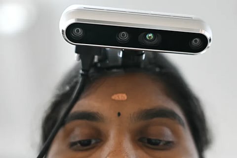 A worker wearing an RGB camera on her head, recording actions through motion capture while arranging coloured blocks at AI data company Objectways' office in Tamil Nadu's Karur