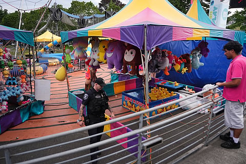 A police officer responds after a shooting at Seattle Center during the Bite of Seattle food festival Sunday, July 26, 2026, in Seattle, Wash.