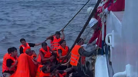 In this photo released by Xinhua News Agency, crew members on Nanhai Jiu 115, a rescue vessel operated by the Nanhai Rescue Bureau of China's Ministry of Transport, pick up crew members of Vietnamese vessel Khoi Nguyen from a life raft in the South China Sea on July 25, 2026. 