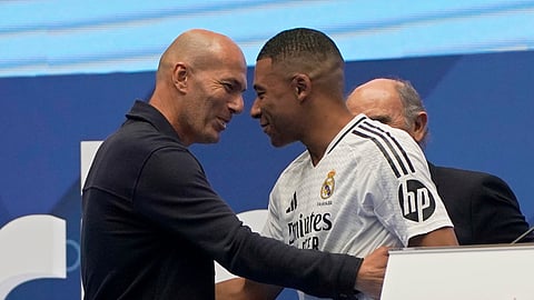 Former French player Zinedine Zidane, left, embraces Kylian Mbappe of France.