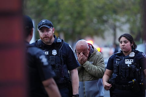 An unidentified man is led into the scene by police after they responded to a shooting at Seattle Center during the Bite of Seattle food festival Sunday, July 26, 2026, in Seattle, Wash