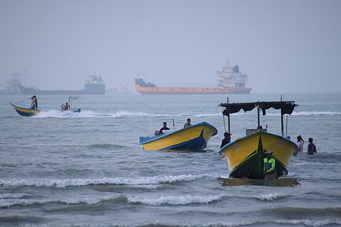 Small boats line the shore as cargo ships and other commercial vessels appear anchored in the Strait of Hormuz off Bandar Abbas, Iran, Monday, July 27, 2026. 