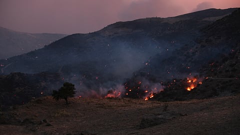 A wildfire burns in the Rethymno region on the southern Greek island of Crete, Wednesday, July 29, 2026, where two firefighters died while battling the blaze.
