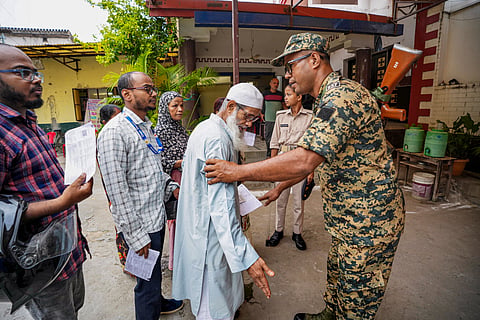  A security official assists a man at a polling station during the the Bankipur Assembly by-election, in Patna, Thursday, July 30, 2026.