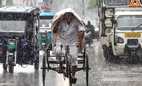 A rickshaw puller covers himself amid rainfall, in Haridwar, Uttarakhand, Thursday, July 30, 2026.