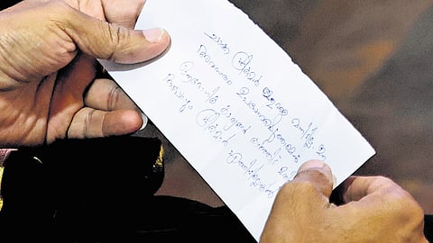 Mayor V V Rajesh is seen reading a note handed to him by a BJP councillor urging him to present the leave application of jailed councillor Sugathan R during the Thiruvananthapuram corporation council meeting on Friday 