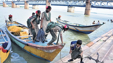Children of fishermen crossing River Godavari by boat from island villages to reach their schools in Rajamahendravaram.