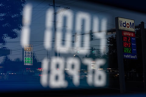FILE - A person secures the fuel nozzel while filling up their tank at a gas station on Tuesday, May 12, 2026, in Portland, Ore.
