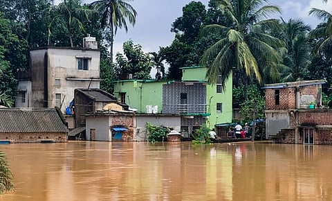 People use a countryboat in floodwater, in Jajpur district, Odisha, Wednesday