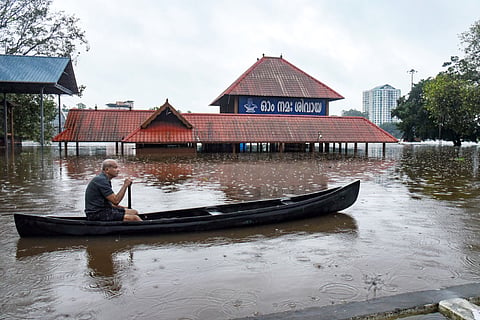  A man paddles a canoe past the inundated Sree Mahadeva Temple in a waterlogged area following heavy rain, in Kochi, Kerala, Saturday, Aug. 1, 2026.