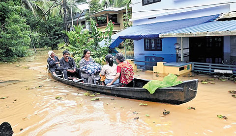 Rescue workers evacuate residents from houses flooded by the overflowing Poonoor river at Anakkayam, Moozhikkal, in Kozhikode on Sunday 