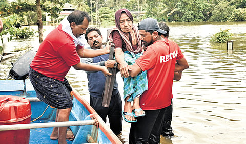 Volunteers evacuate residents stranded in flooded houses at Kanjiraveli near Aranmula on Monday.
