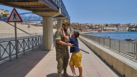 A 12-year-old unaccompanied minor who crossed into Spain is escorted by a Spanish soldier to the Spain-Morocco border as the child begs not to be sent back to Morocco from the Spanish enclave of Ceuta, Monday, Aug. 3, 2026.