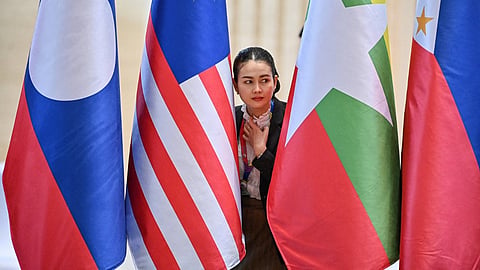 A police official looking on between participating national flags during an ASEAN session