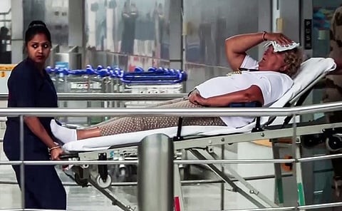 A staff member is present with an injured passenger on a stretcher after several passengers, including crew members, got injured as Air India flight (AI2379) from Phuket to Delhi experienced a brief in-flight turbulence, in New Delhi on Tuesday. 