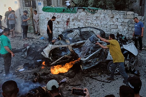 Palestinians try to extinguish a burning car after an Israeli military strike in Gaza City, Sunday, Aug. 2, 2026.