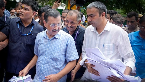 Former Delhi chief minister and AAP chief Arvind Kejriwal and party leader Anurag Dhanda interact after they were stopped by the police during their protest march towards the Prime Minister's residence with around 100 people to submit over 2.30 lakh petitions against E20 petrol, in New Delhi, Tuesday, Aug. 4, 2026.
