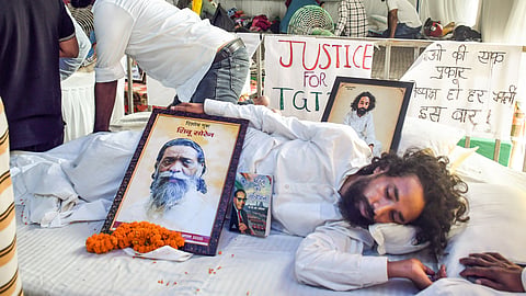 Student leader Divendranath Mahato sits on a hunger strike to protest the alleged JPSC examination paper leak, with a framed photograph of late Shibu Soren as a symbol of justice on his death anniversary, at Jaipal Singh Stadium in Ranchi on Tuesday, Aug. 04, 2026.