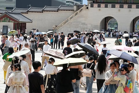 Visitors hold umbrellas to avoid sunshine at the Gyeongbok Palace in Seoul, South Korea, Wednesday, August 5, 2026.