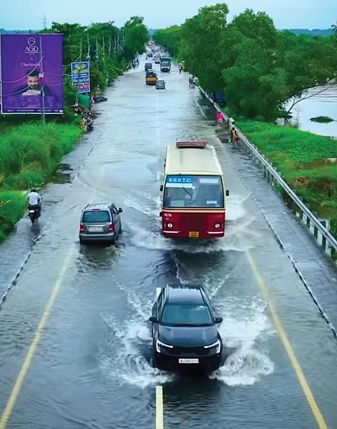 Vehicles moving through the flooded AC Road.