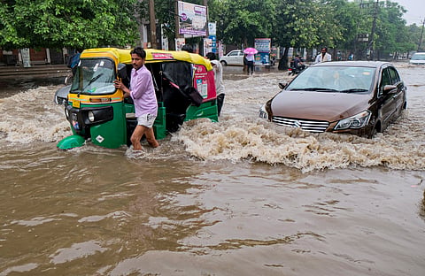 Commuters move on a waterlogged road following rainfall, in Gurugram, Haryana, Thursday, Aug. 6, 2026.