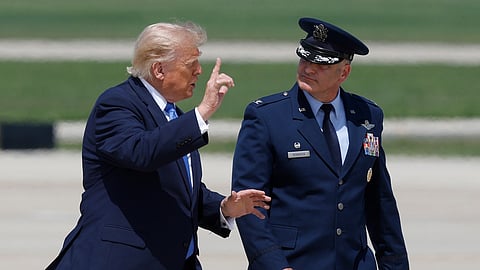 President Donald Trump, left, is escorted by Air Force Col. Christopher M. Robinson, commander of the 89th Airlift Wing, right, as he walk from Marine One to Air Force One, at Joint Base Andrews, Md., Tuesday, Aug. 4, 2026.