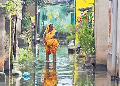 A woman wades through a waterlogged path in Bhubaneswar on Thursday.
