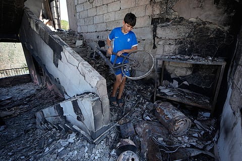 A Lebanese boy removes part of his damaged bicycle from his destroyed house in the village of Zawtar al-Gharbieh, south Lebanon, Wednesday, Aug. 5, 2026.