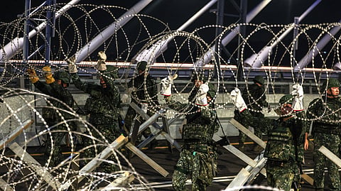 Taiwanese soldiers deploy concertina wire barriers during a blockade drill held as part of the annual Han Kuang military exercise, in New Taipei City on August 6, 2026.