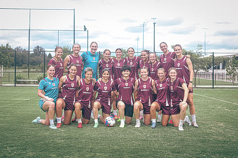 Iranian soccer players Atefeh Ramezanizadeh and Fatemeh Pasandideh (both bottom centre) pose for a photo with members of Brisbane Roar women's football club, in Brisbane, Australia, March 16, 2026.