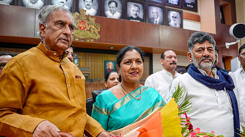 In this image posted on Aug. 7, 2026, Karnataka Legislative Council Chairman Basavaraj Horatti and state Chief Minister DK Shivakumar with newly-elected state MLC AV Gayathri Shantegowda during the latter's swearing-in ceremony, at the office of the Chairman, in Bengaluru.