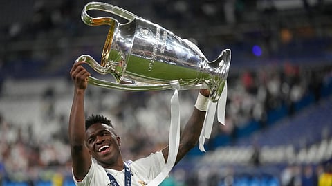 Real Madrid's Vinicius Junior holds up the trophy after winning the Champions League final soccer match between Liverpool and Real Madrid in Saint Denis near Paris, May 29, 2022.