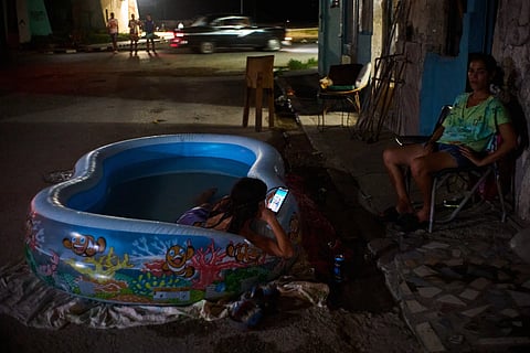 A girl cools off in a plastic pool in the street in Havana, Cuba, Tuesday, Aug. 4, 2026. 