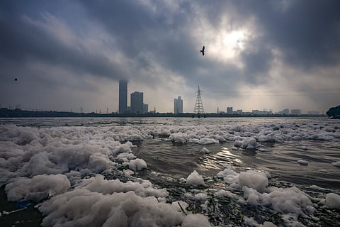 Clouds hover over the Yamuna river, where a thick layer of toxic foam floats on the water during monsoon, at Kalindi Kunj, in Okhla, Delhi