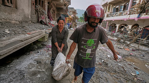 Residents salvage their belongings from damaged houses after flash flooding in the Devighat area of Nuwakot district in Nepal.