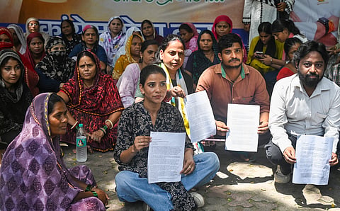 Residents from BR Camp, Masjid Camp, and DID Colony, gather outside the AICC headquarters holding documents to seek the intervention of Congress leader Rahul Gandhi regarding their rehabilitation and relocation issues, in New Delhi, Saturday, Aug. 29, 2026.