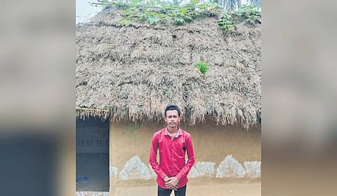 Somya Ranjan standing in front of his thatched house at Sahabajpur village.
