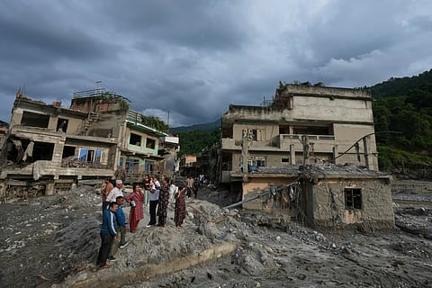 Residents and others look at damaged structures after flash flooding in the Devighat area of the Nuwakot district in Nepal, Friday, Aug. 28, 2026.