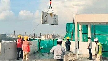 Workers prepare to carry out controlled demolition of apartment units at SNN Raj Etternia on Friday .