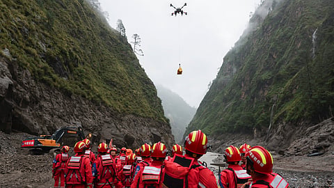 In this photo released by Xinhua News Agency, a drone carries cargo overhead as search and rescue operations are underway at the mudslide-hit area in Gyirong County, southwestern China's Tibet Autonomous Region, on Saturday, Aug. 29, 2026.
