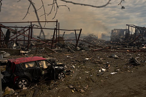 Destroyed vehicles and debris are scattered the day after a Russian attack struck a warehouse, followed by an explosion, in the village of Myla, outskirts of Kyiv, Sunday, Aug. 30, 2026