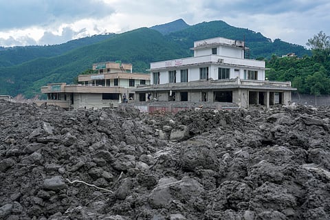 Commercial structures stand heavily damaged behind massive deposits of rocks, silt, and thick mud at Trishuli Bazar, in Nuwakot district, Nepal, Monday, Aug. 31, 2026. 