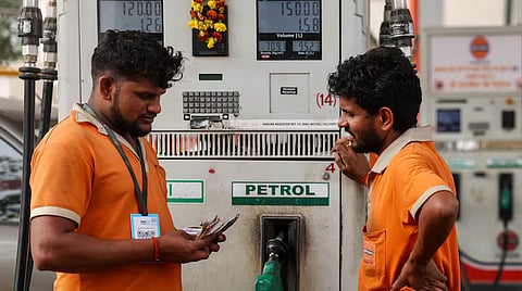 Petrol pump attendants count currency notes after refuelling a vehicle at an Indian Oil fuel station in Varanasi on March 2026