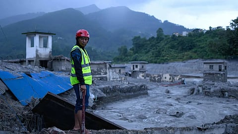 A disaster rescue personnel looks on at the site of damaged buildings in the aftermath of flash floods at Trishuli Bazar in Nepal's Nuwakot district on Saturday
