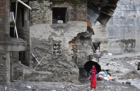 A woman walks among the ruins of flash floods in Nepal's Nuwakot district on September 1, 2026.