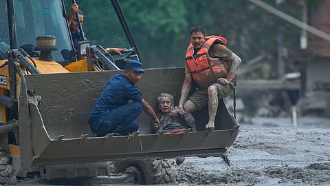 Rescuers use an earthmover to carry a victim of flash flooding to safety along the Trishuli River in Nepal’s Nuwakot district, Wednesday, Aug. 26, 2026. 