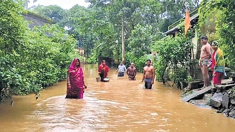 Residents standing in knee-deep floodwater at Madhuban on Tuesday.
